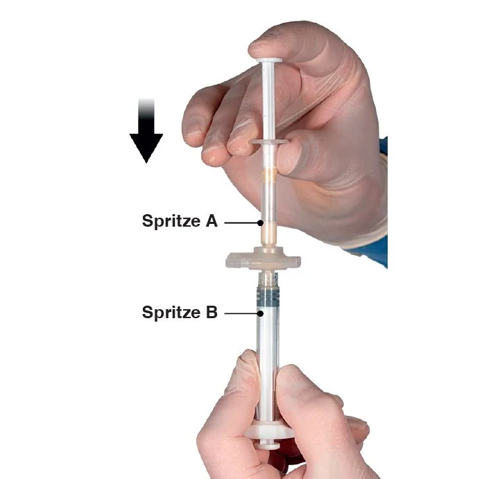 A close-up of hands holding a syringe

Description automatically generated